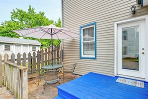 A patio with a table and chairs, a striped umbrella, and a blue welcome mat. - Walk to Dtwn Seneca Falls: Family Retreat w/ Yard! (Seneca Falls)