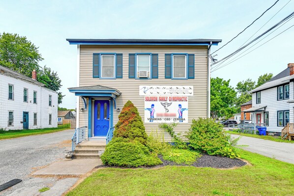 A two-story building with a blue door and a sign advertising a family chiropractic clinic.