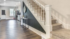 A modern kitchen with dark wooden floors, a white staircase, and a dark accent wall. - 9 Mi to Shawnee Mtn! Stroudsburg Unit Near Main St (Stroudsburg)
