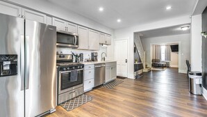 A modern kitchen with stainless steel appliances, white cabinetry, and hardwood flooring. - 9 Mi to Shawnee Mtn! Stroudsburg Unit Near Main St (Stroudsburg)