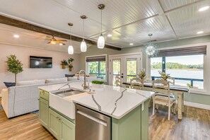 A modern kitchen with a large island, built-in appliances, and a view of the outdoors. - Bayfront Milton Retreat With Dock & Game Room (Milton)