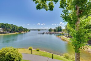 A river with a dock, surrounded by greenery and a clear sky. - Clemson Game Retreat: Lakefront Keowee Key Condo (Salem)