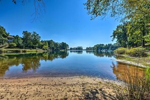 A serene lakeside view with a clear sky, calm water, and surrounding greenery. - Clemson Game Retreat: Lakefront Keowee Key Condo (Salem)