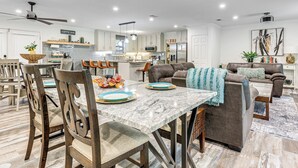 A spacious living area with a dining table, chairs, and a sofa.