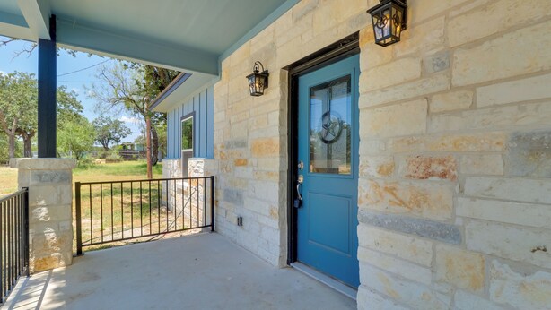 A stone building with a blue door and a covered porch. - 1 Mi to Lake Lbj: Peaceful Home w/ Patio & Yard! (Marble Falls)