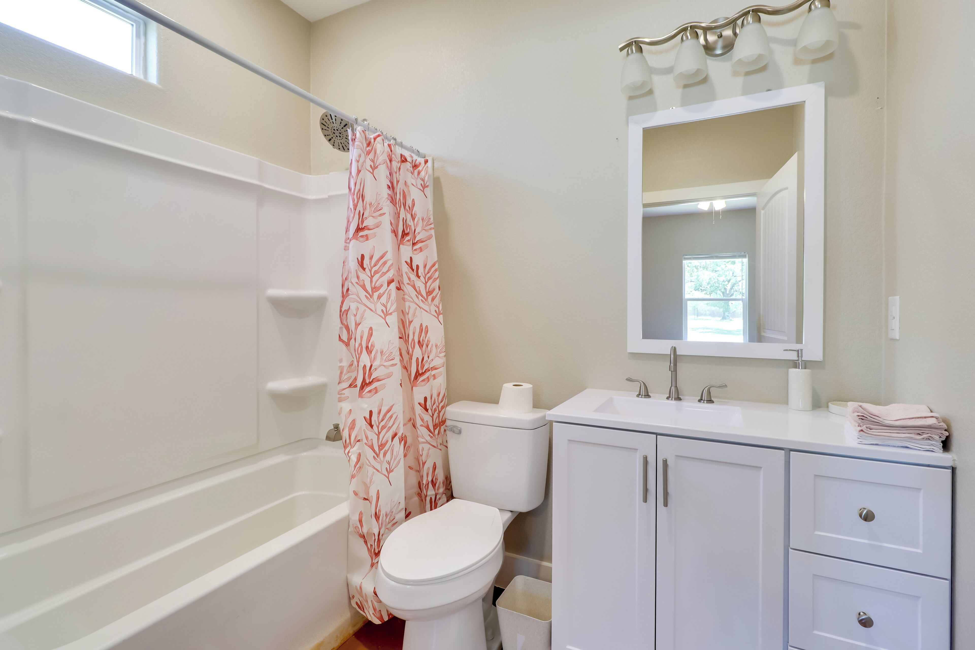 A bathroom with a bathtub, toilet, sink, and vanity.