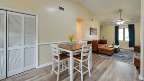 A dining area with a wooden table and chairs, a sofa, and a ceiling fan. - Game Day Ready: Greenville Stay w/ Patio Dining (Greenville)