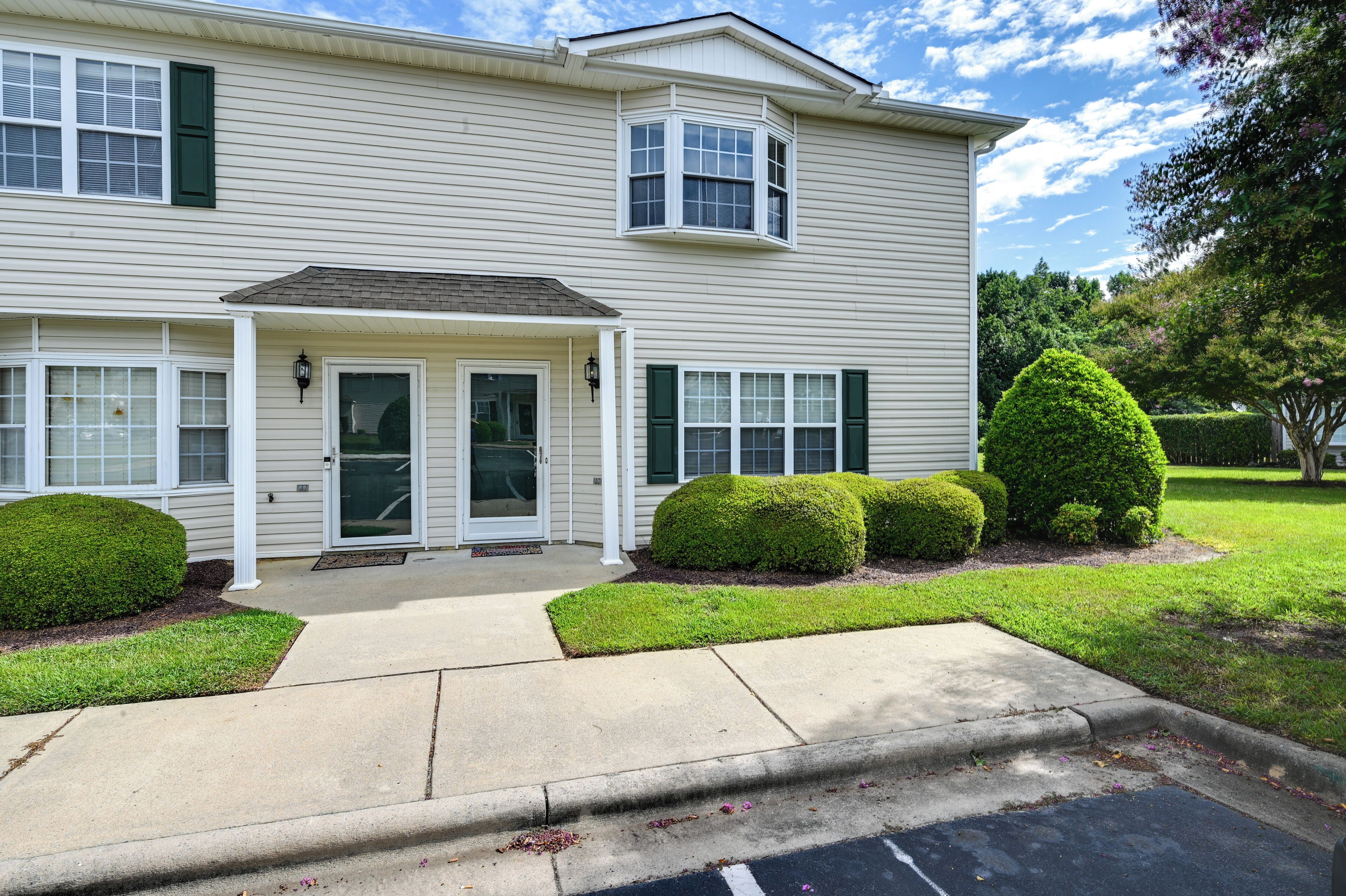 A two-story house with a front porch, a small entryway, and a driveway.