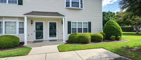 A two-story house with a front porch, a small entryway, and a driveway.