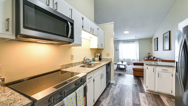 A modern kitchen with stainless steel appliances, white cabinetry, and a granite countertop. - Easy ECU Access: Modern Home w/ Patio! (Greenville)