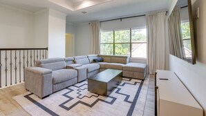 A modern living room with a sectional sofa, a coffee table, and a TV. - Yard & Workspaces: Luxe Duplex Unit in Houston (Houston)