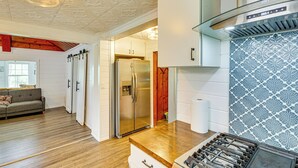 Una cocina moderna con refrigerador de acero inoxidable, piso de madera y salpicadero con diseño.