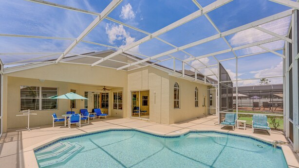 A covered outdoor swimming pool with blue chairs and a patio area. - Heated Pool, 9 Mi to Disney: Davenport Haven! (Davenport)