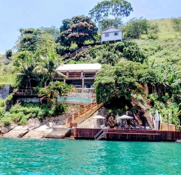 Un resort con piscina, una escalera que lleva a una casa y abundante vegetación.