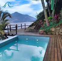 Una piscina al aire libre, sombrillas, sillones reclinables de piscina