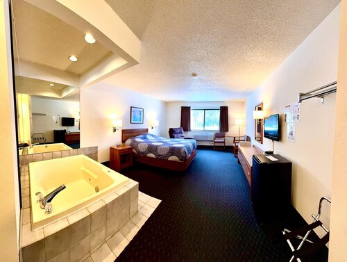 One queen bed, private bathroom, two-person whirlpool tub, mini fridge, and single-serve coffee maker.