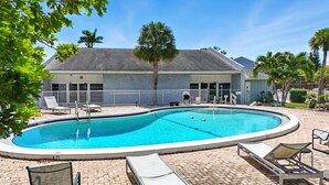 A swimming pool with lounge chairs and a fenced deck area. - Naples Retreat - Walk to Pool and More (Naples)