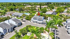 A residential area with houses, a swimming pool, and a red marker. - Naples Retreat - Walk to Pool and More (Naples)