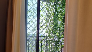 Een balkon met uitzicht op groen en een betegelde vloer.