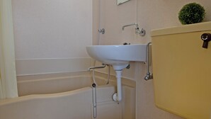 Ein Badezimmer mit Toilette, Waschbecken, Spiegel und Handtuchhalter.