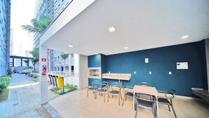 A modern outdoor dining area with a blue accent wall, a white ceiling, and a tiled floor. - Apartamento no centro de SP - 1209A (São Paulo)