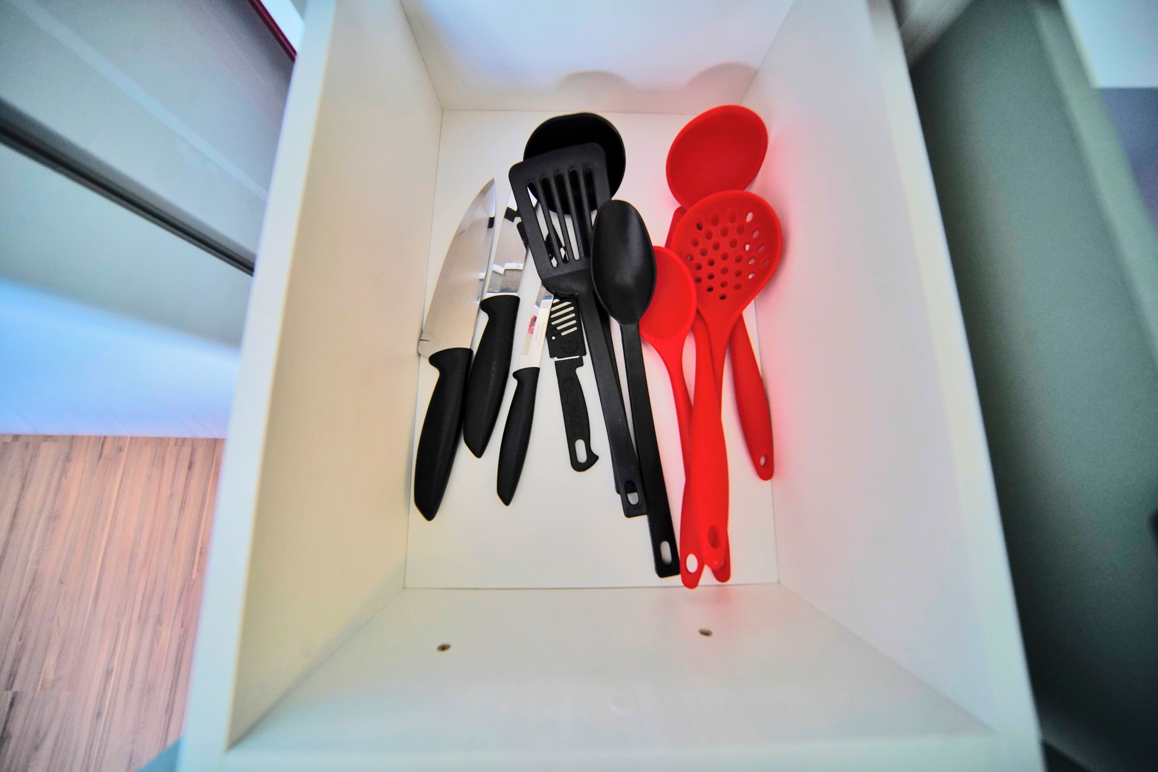 A drawer with kitchen utensils including spatulas and a knife.
