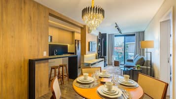 Una habitación de hotel moderna con comedor, cocina y sala de estar con vistas.