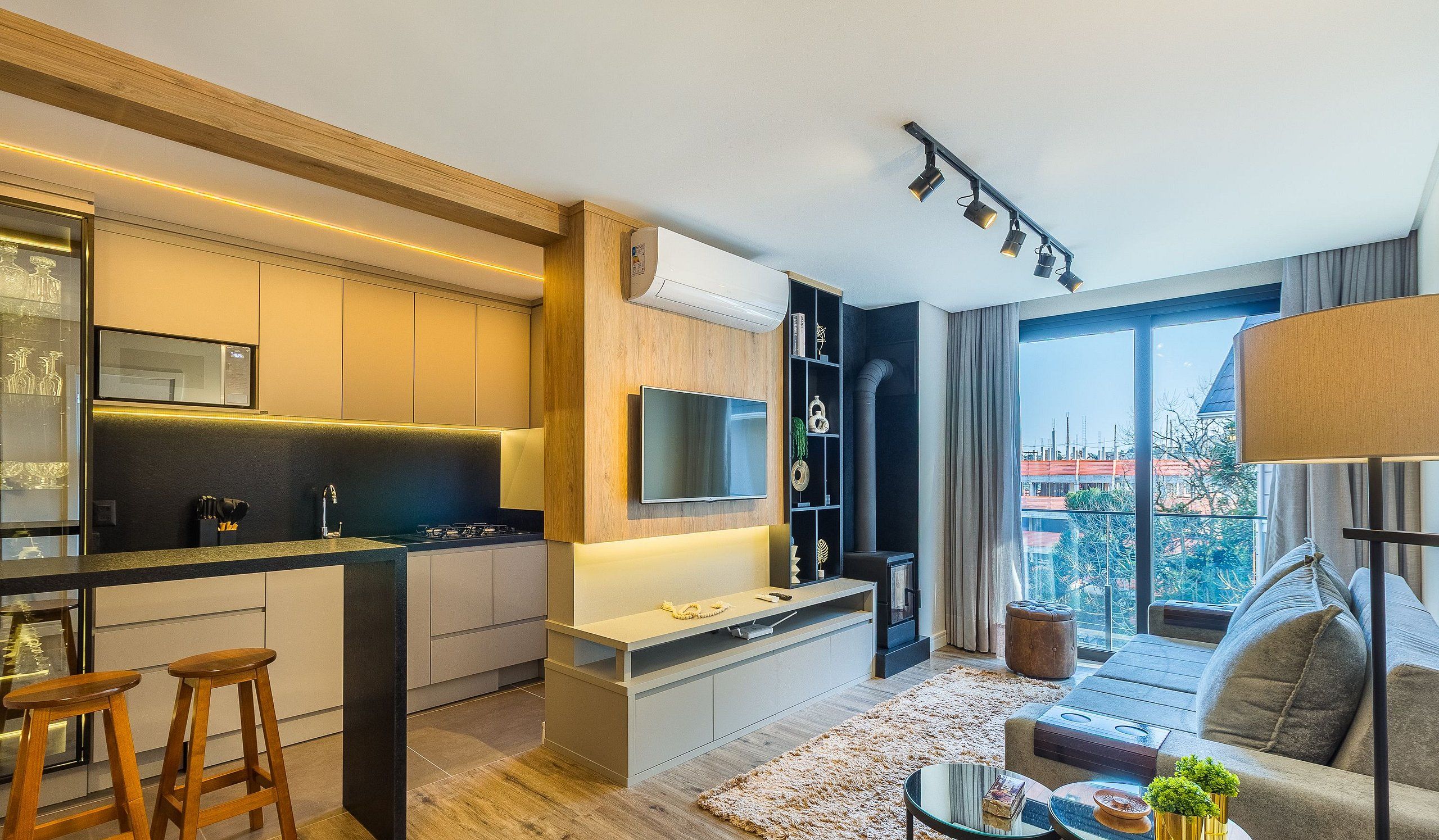 Un apartamento moderno con cocina, sala de estar y ventanas amplias que ofrecen vista a la ciudad.
