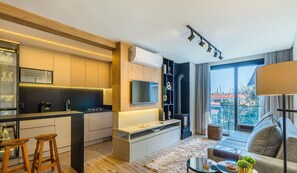 A modern apartment with a kitchen, living area, and large windows offering a city view. - Charming apartment with fireplace in Gramado STA0305 (Gramado)