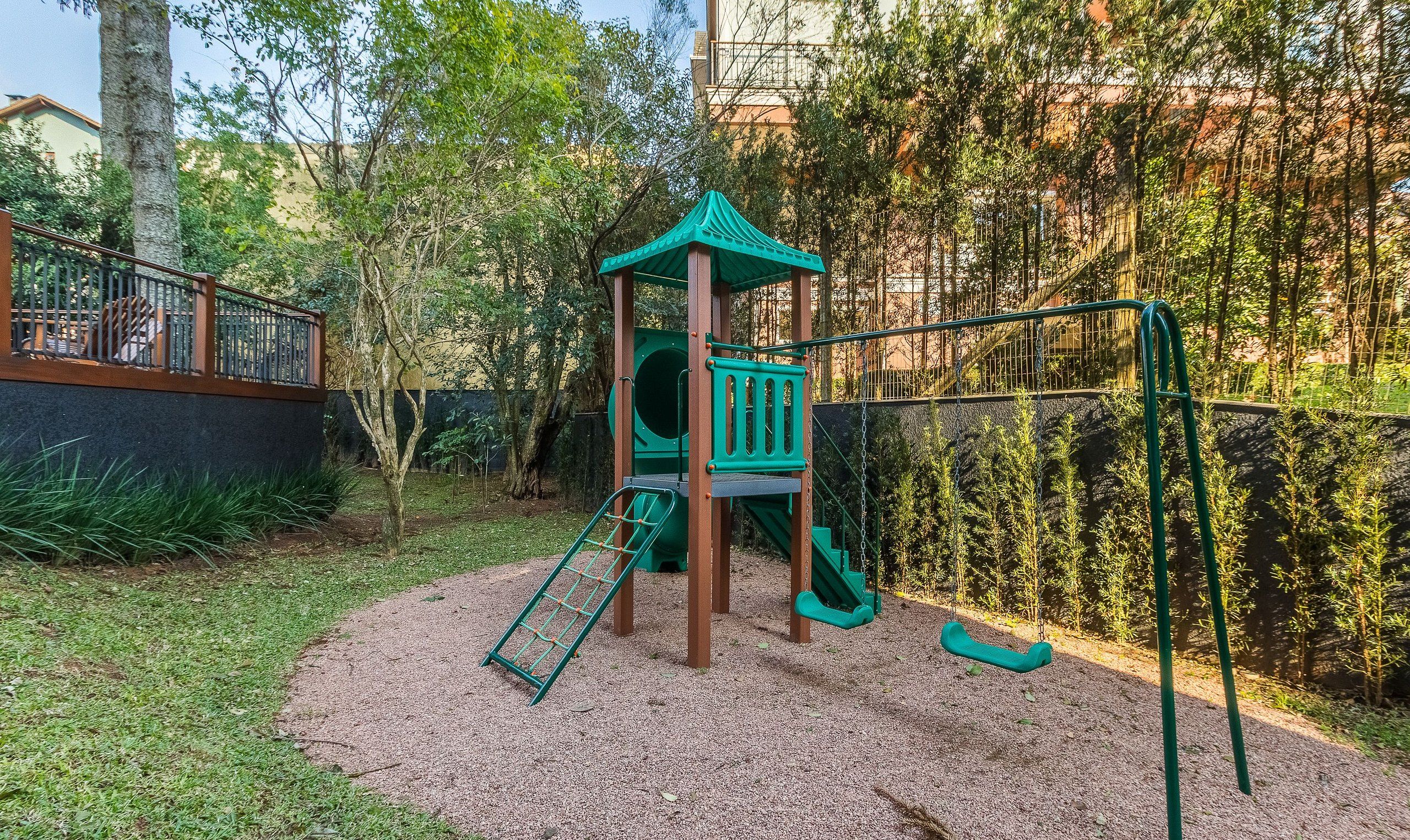 A playground with a climbing structure, slides, and swings.
