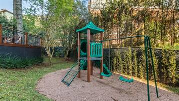 A playground with a climbing structure, slides, and swings.