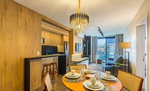 A modern hotel room with a dining area, a kitchen, and a living area with a view. - Charming apartment with fireplace in Gramado STA0305 (Gramado)