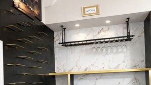 Ein modernes Interieur mit Schwarz-Gold-Dekor, einem Weinkühler und einer Marmorwand.