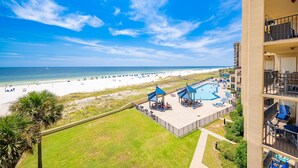 A beachfront hotel with a pool area, beach access, and a view of the ocean.