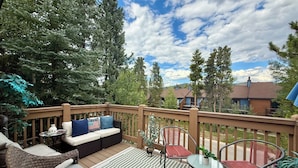 A deck with outdoor furniture, including a sofa, chairs, and a table.