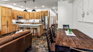 A modern kitchen with wooden cabinets, stainless steel appliances, and a central island.
