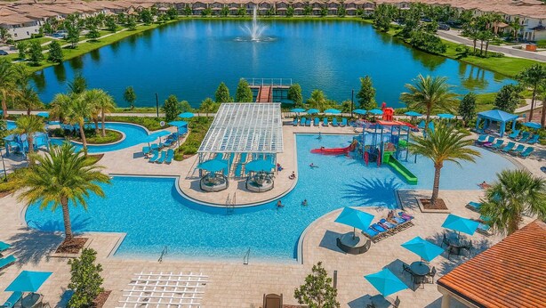 Um resort com piscina central, escorrega e fonte.