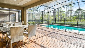 An outdoor patio with wicker furniture and a pool. - Luxury Home with Private Pool in Kissimmee (Kissimmee)