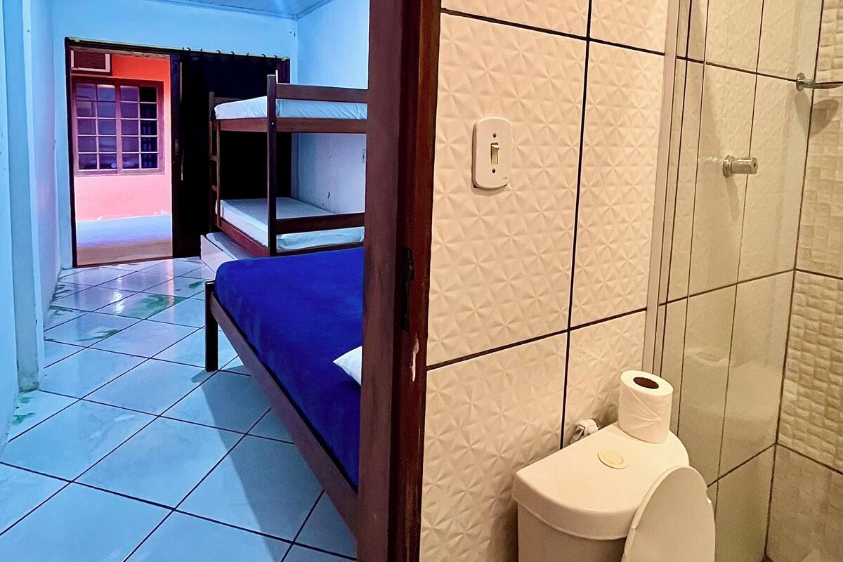 Une pièce avec des lits superposés, des toilettes et un espace douche.