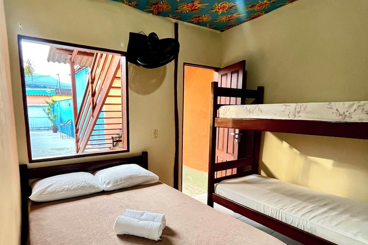 Une chambre avec deux lits, une fenêtre donnant sur un beau paysage et un plafond orné de motifs floraux.