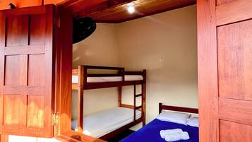 Habitación con literas, paredes de madera y una ventana.