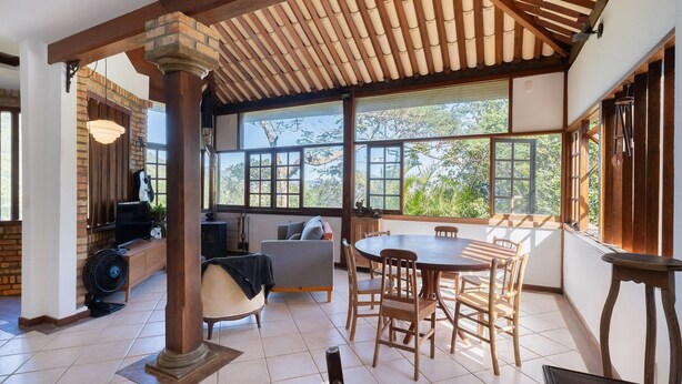 A spacious room with a large dining table, wooden chairs, and a view of greenery through large windows. - House With BBQ 550m From the Beach Gss0488 (Florianópolis)