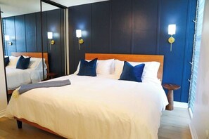 Ein Hotelzimmer mit einem großen Bett, Nachttischen und Wandlampen.