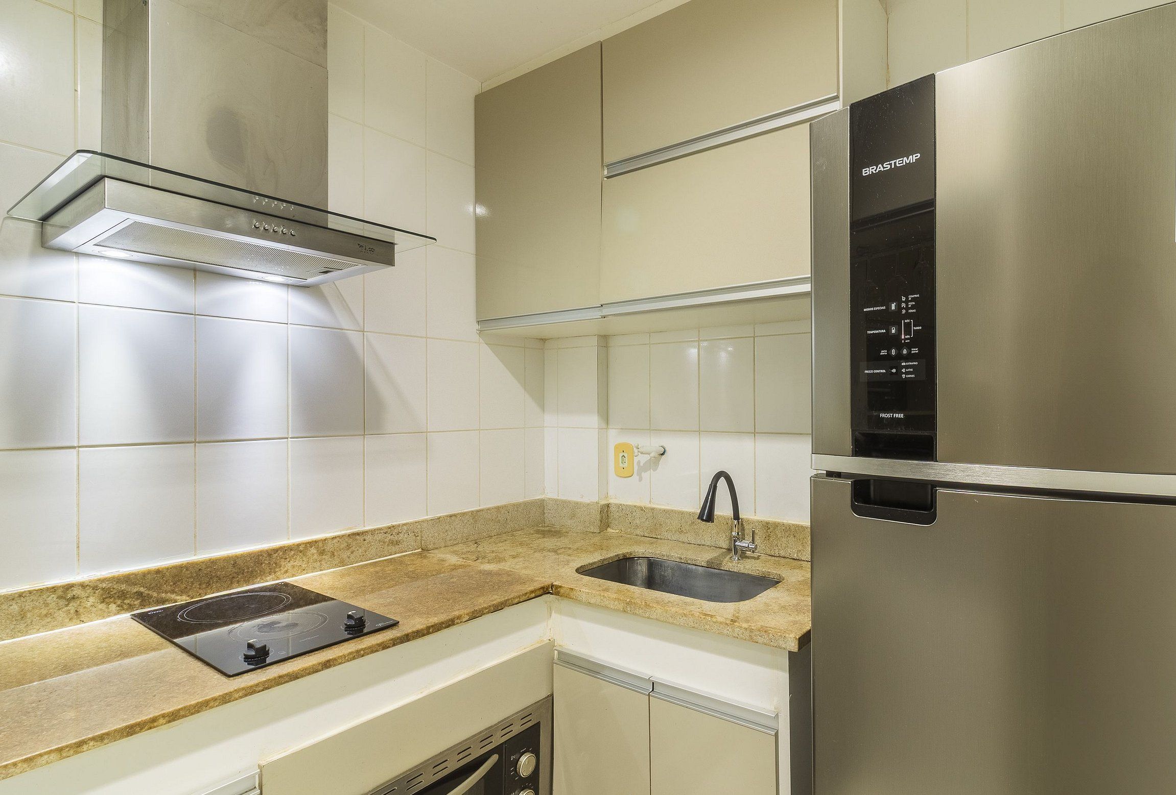 A modern kitchen with stainless steel appliances, a built-in oven, and a granite countertop.