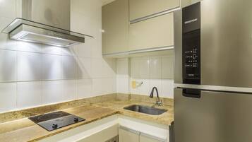 A modern kitchen with stainless steel appliances, a built-in oven, and a granite countertop.