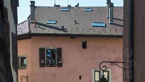 A narrow street with a pink building featuring multiple windows and doors. - Stylish & Cosy Mezzanine in Historical Old Town (Annecy)