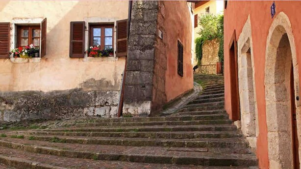 A stone staircase leading up to a building with arched doorways and a sign indicating the number 6. - Stylish & Cosy Mezzanine in Historical Old Town (Annecy)