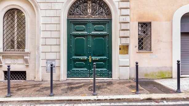 A building with a green double door, a small window with a metal grille, and a number '45' on the wall. - TREVI CHIC HOUSE CENTER OF ROME (Roma)