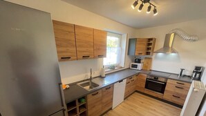 Una cocina moderna con armarios de madera, electrodomésticos de acero inoxidable y un horno empotrado.