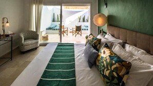 Una camera da letto con un letto, una sedia, un tavolo e vista all'esterno.